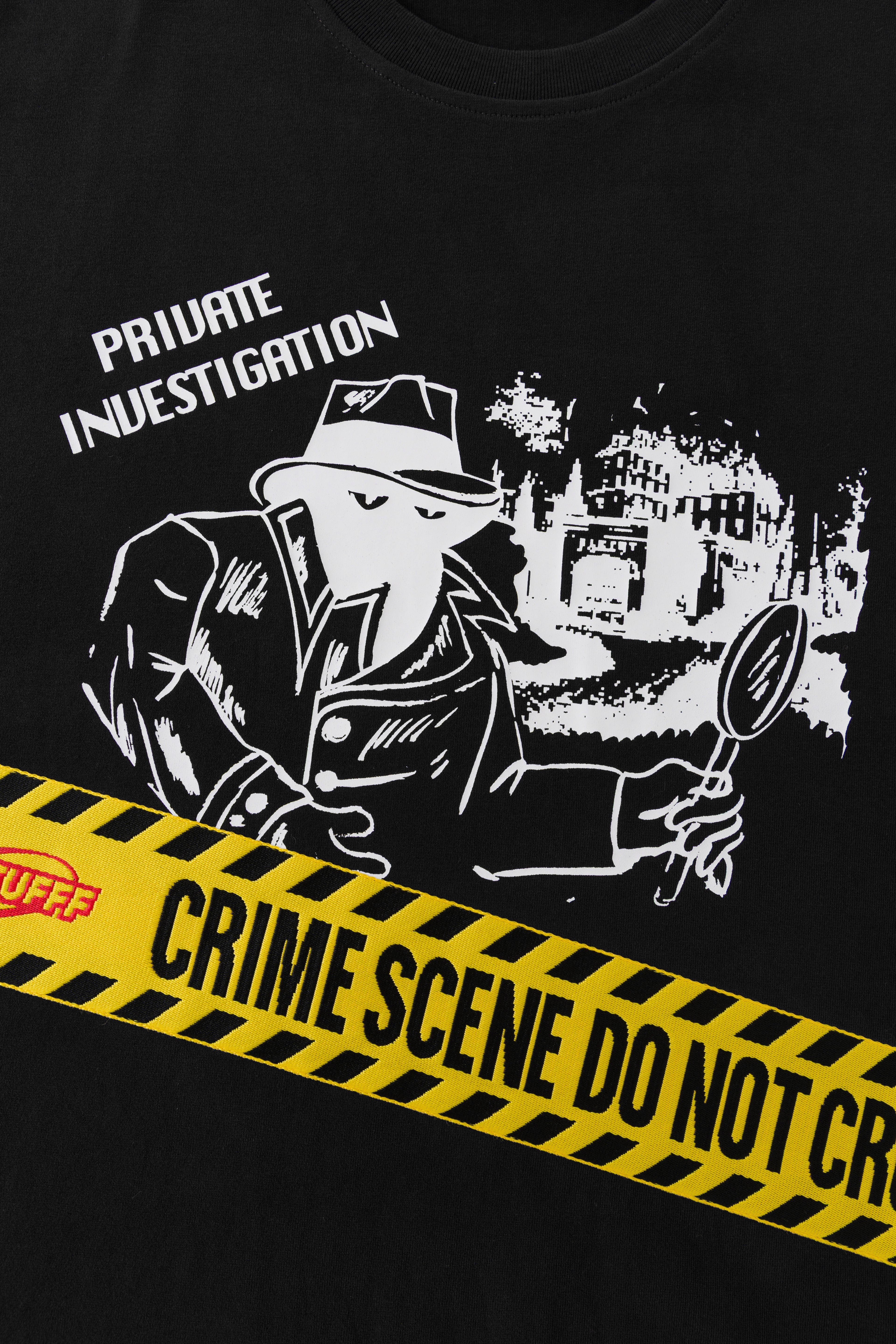 Close-up of the detective print with the nylon jacquard CRIME SCENE DO NOT CROSS tape running across the chest.