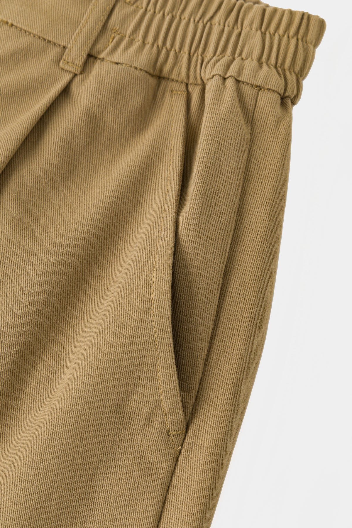 Detail of the slanted side pocket on the beige twill.