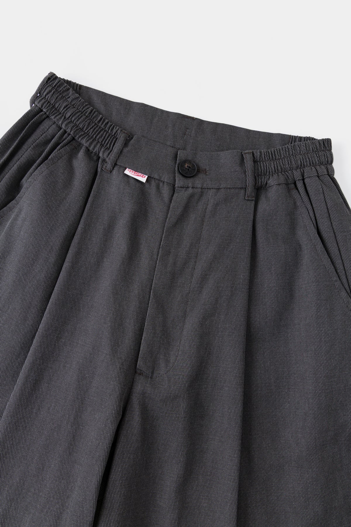 Close-up of the elasticated waistband, front pleats and red Ssstufff tab.