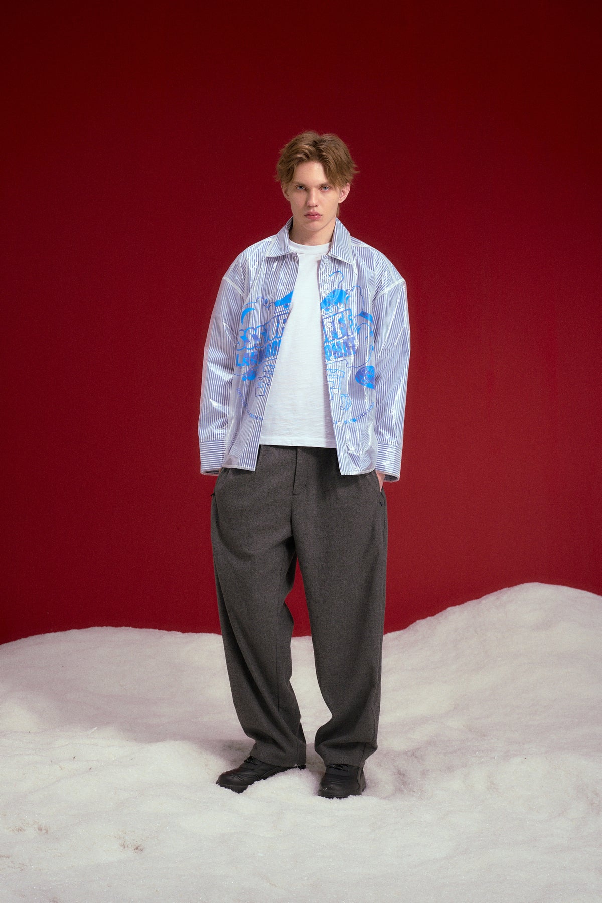 Dry Cleaned Shirt, a blue striped shirt sealed inside a printed dry cleaner's garment bag. Worn on a model, full-length front view, worn open.