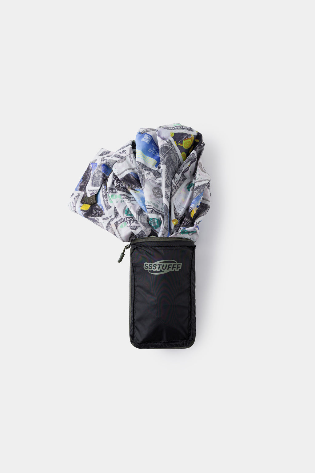 The jacket folded down into the black SSSTUFFF wallet pouch, print spilling out of the top.