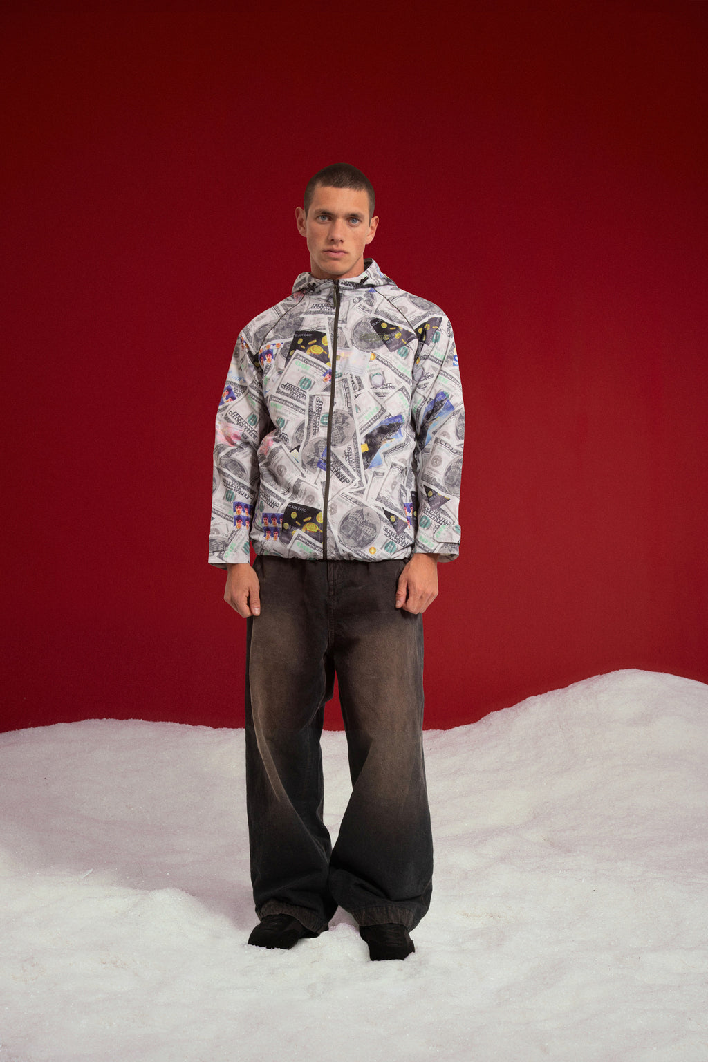 Exploding Wallet Money Windbreaker, printed all over with dollar bills and credit cards. Worn on a model, full-length front view.