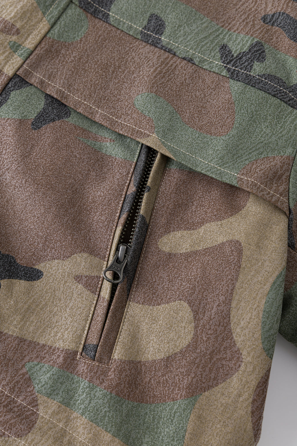 Close-up of the zipped chest pocket on the camo shell.