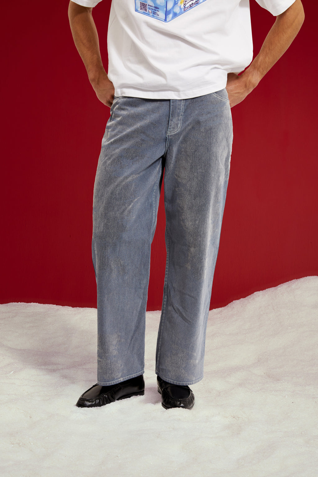 Flock Denim in washed light blue, a flocked wide leg jean. Worn on a model, close-up detail, front.
