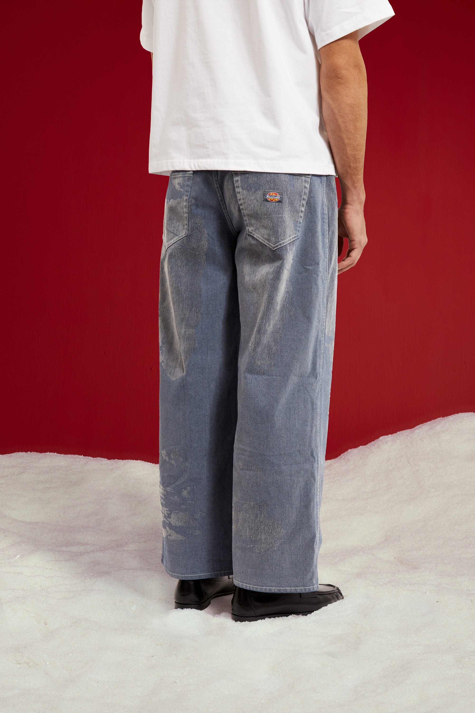 Flock Denim in washed light blue, a flocked wide leg jean. Worn on a model, close-up detail, back.