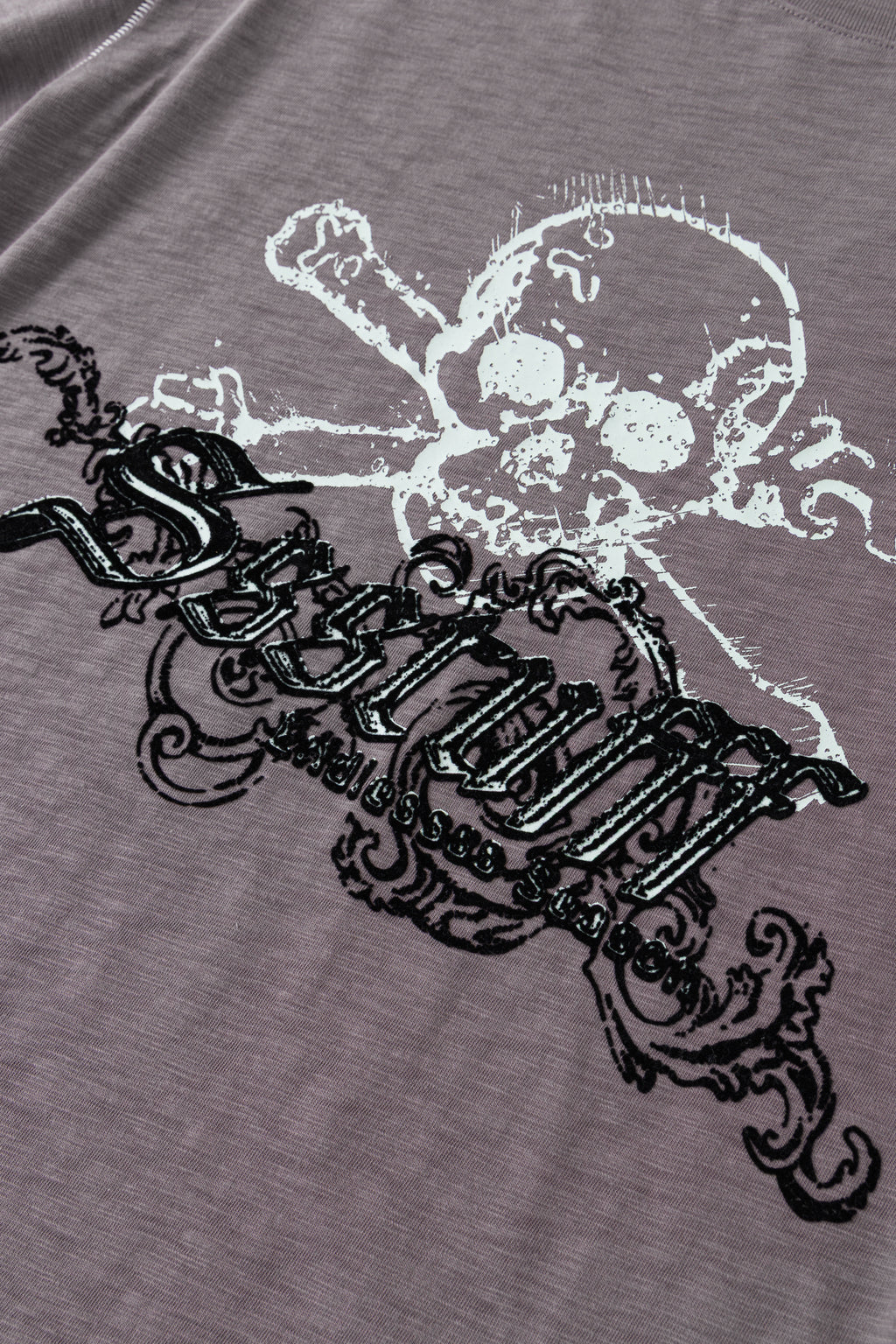Detail of the raised black flock lettering across the skull graphic.