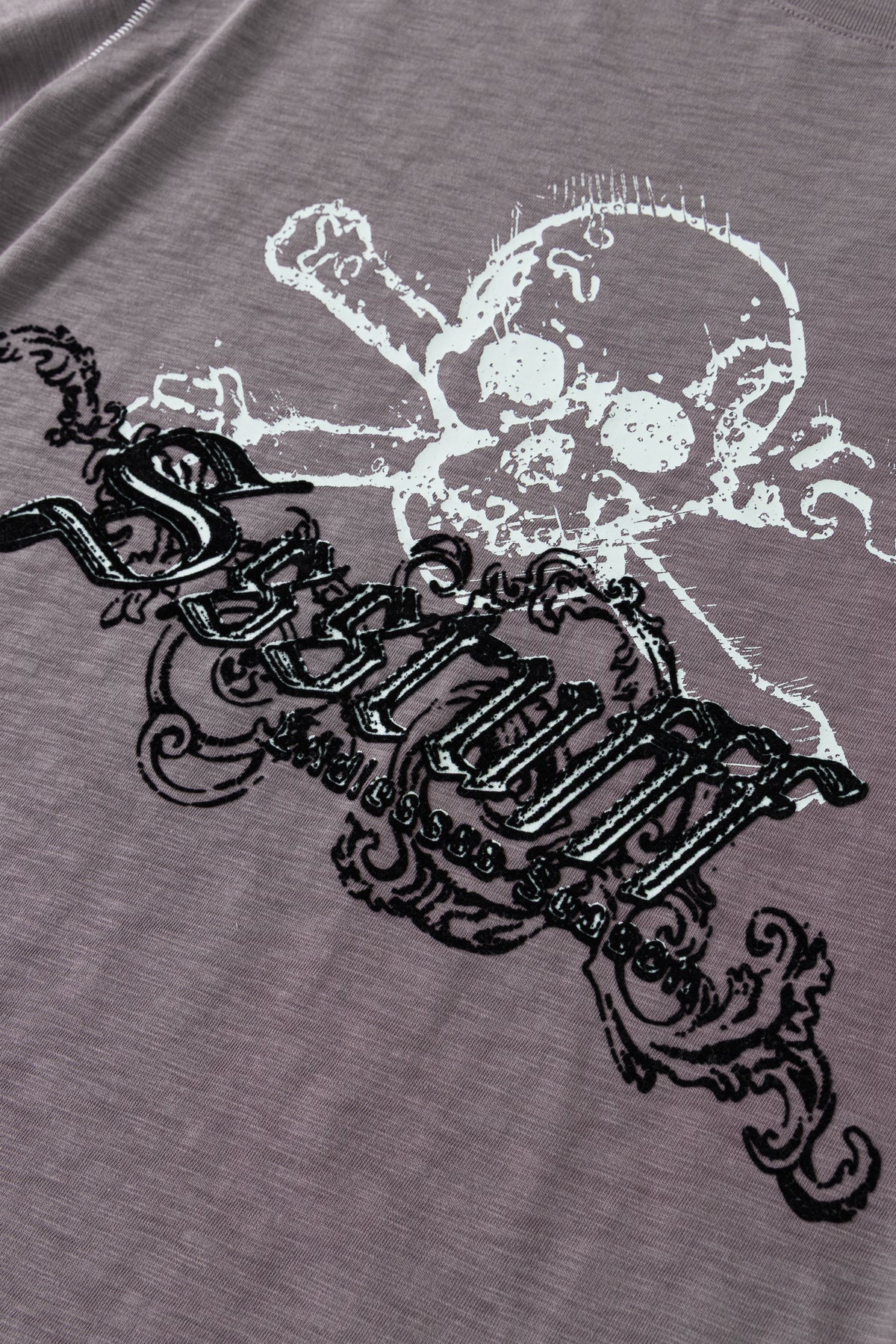 Detail of the raised black flock lettering across the skull graphic.