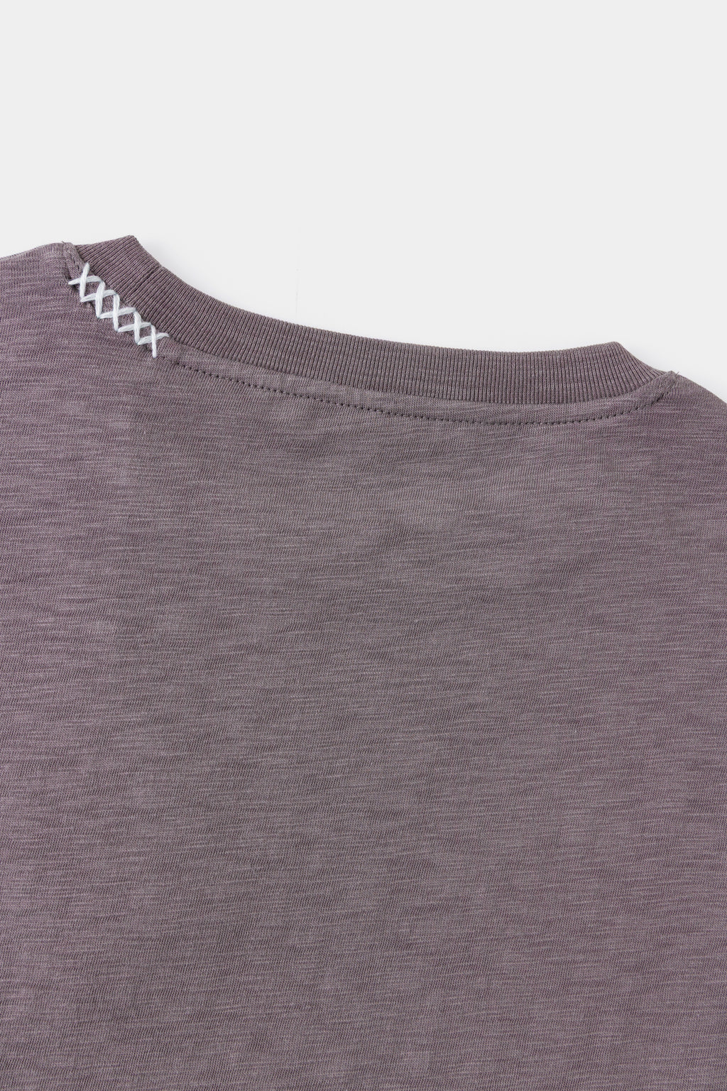 Detail of the shoulder seam and contrast stitching on slub jersey.