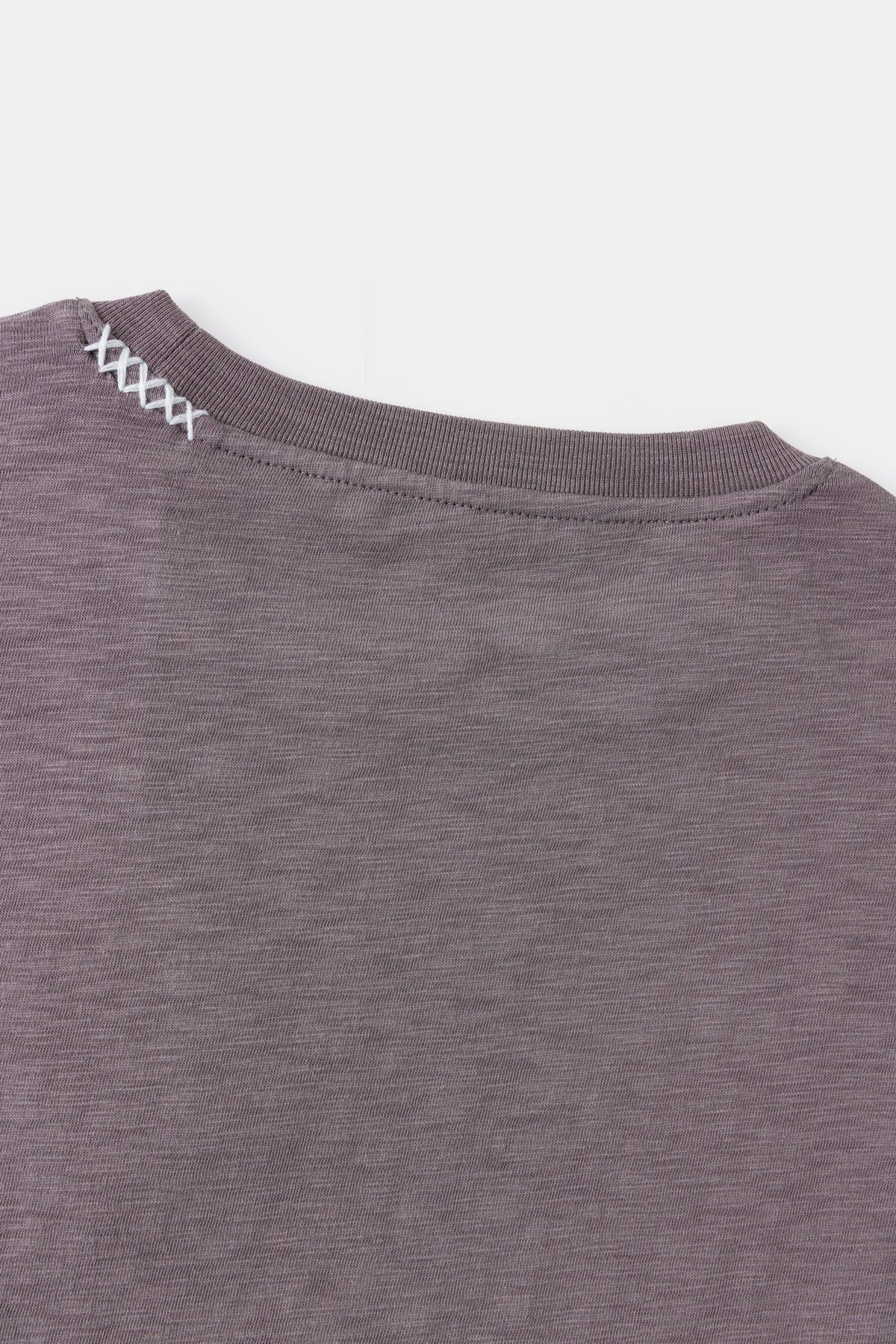 Detail of the shoulder seam and contrast stitching on slub jersey.