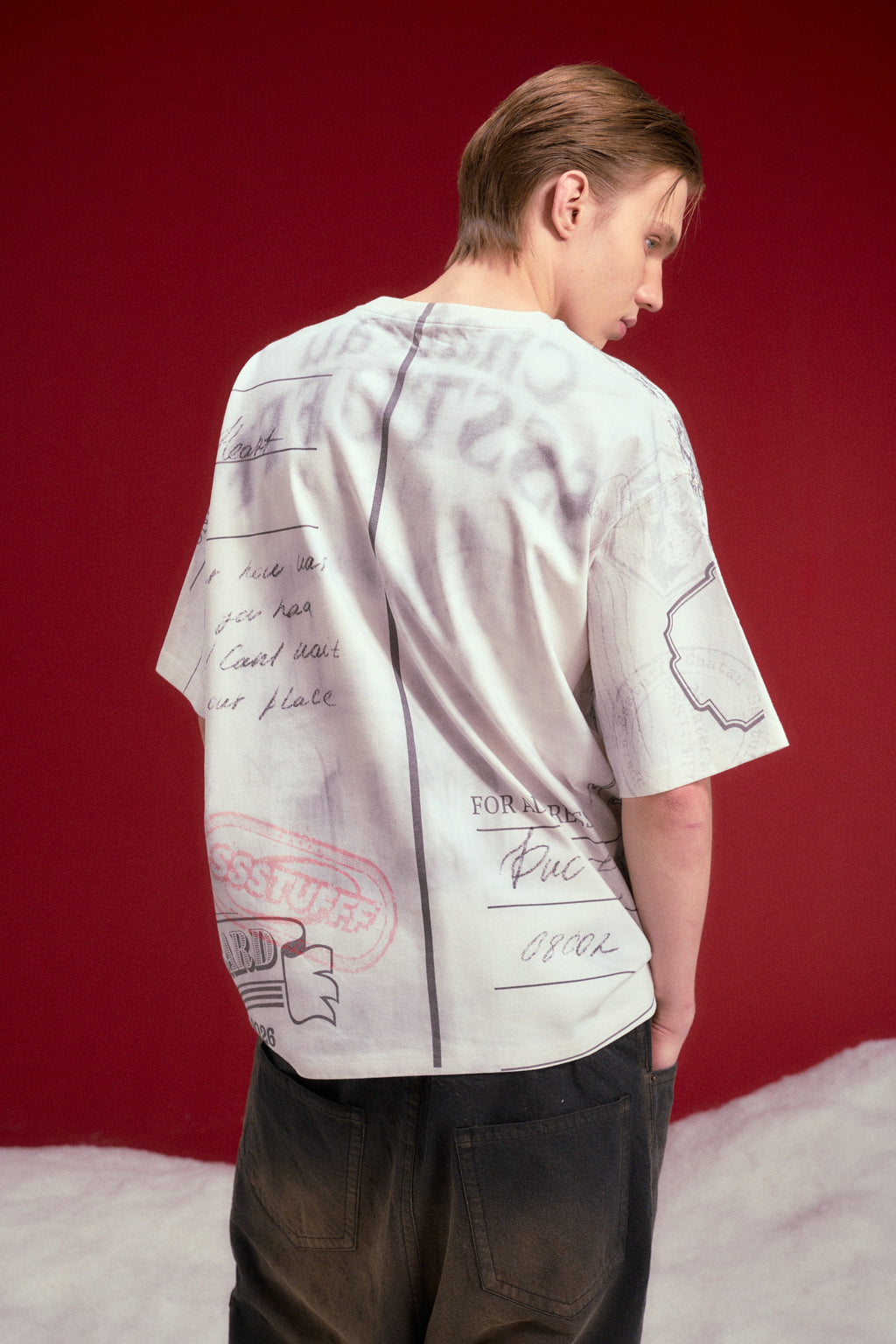 AOP Print Postcard Tee worn on a male model, waist-up back view.