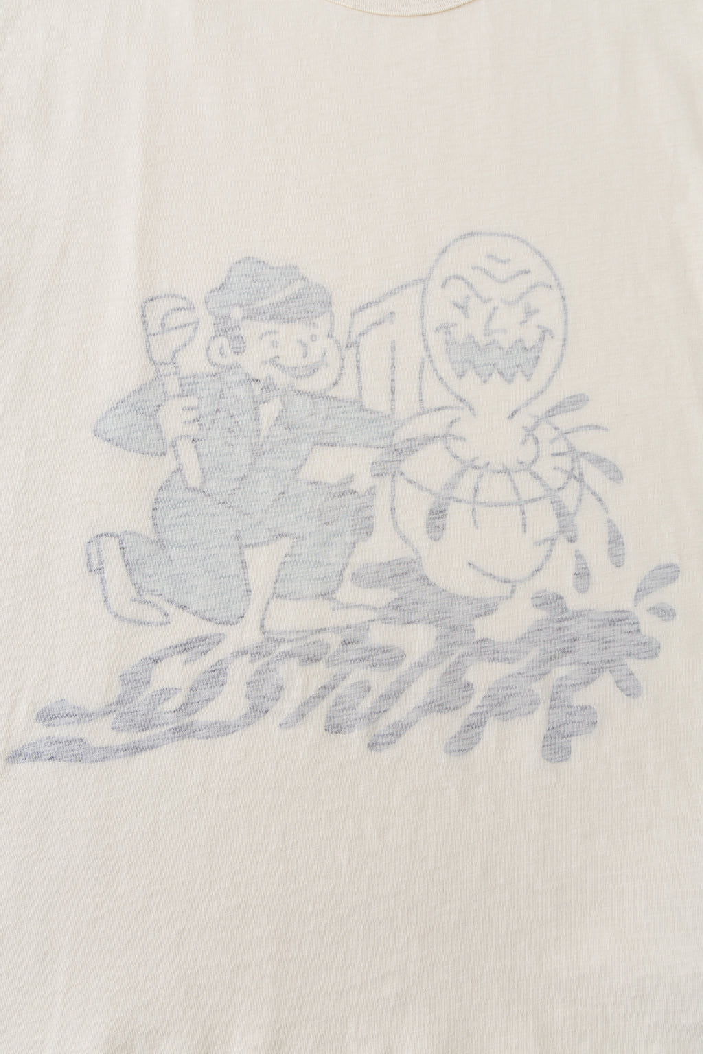 Close-up of the plumber and monster graphic showing through the cream cotton from the inside.