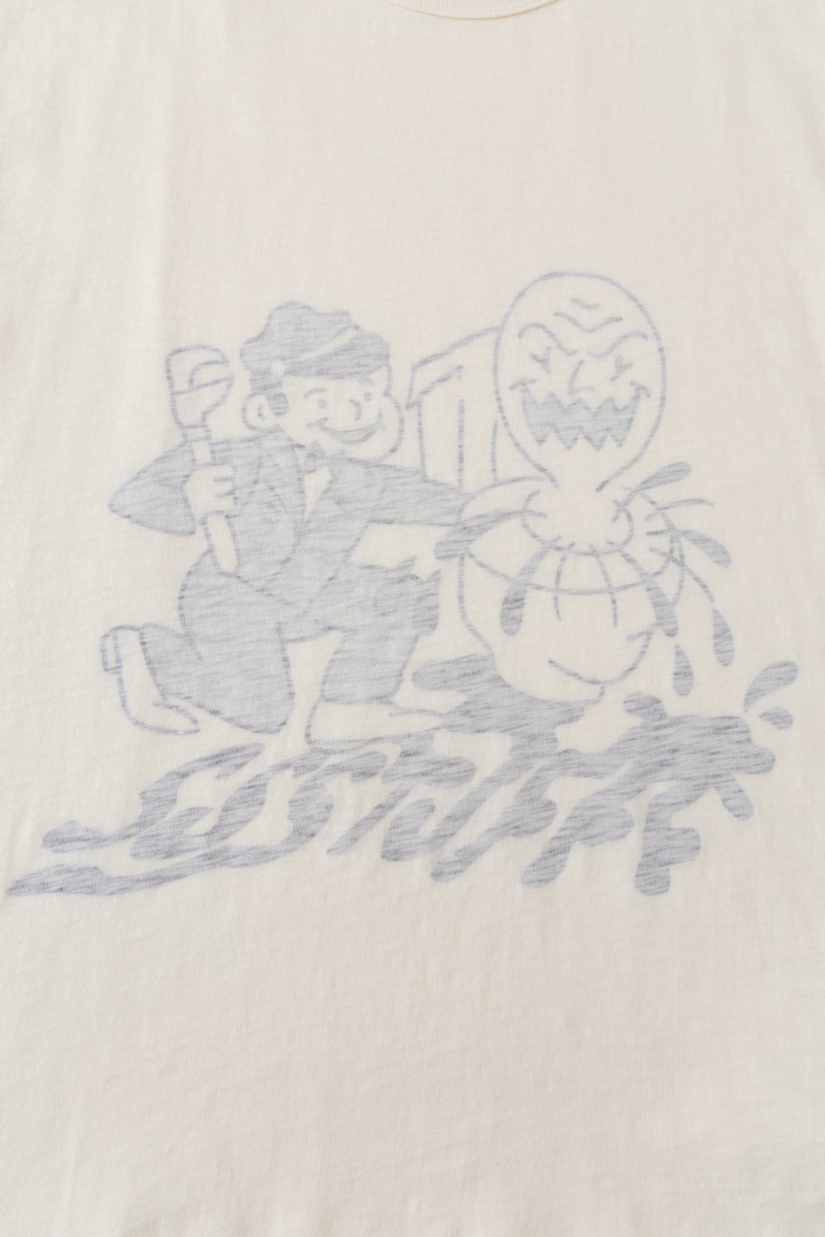 Close-up of the plumber and monster graphic showing through the cream cotton from the inside.