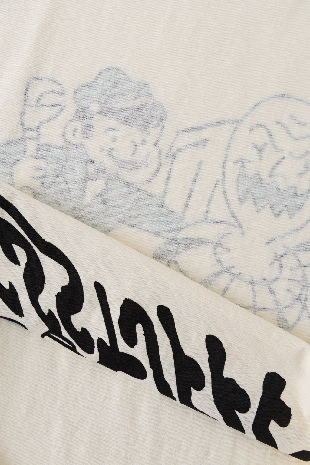 Close-up of the hem turned back, showing the black plumber print on the inside and its faint shadow on the outside.