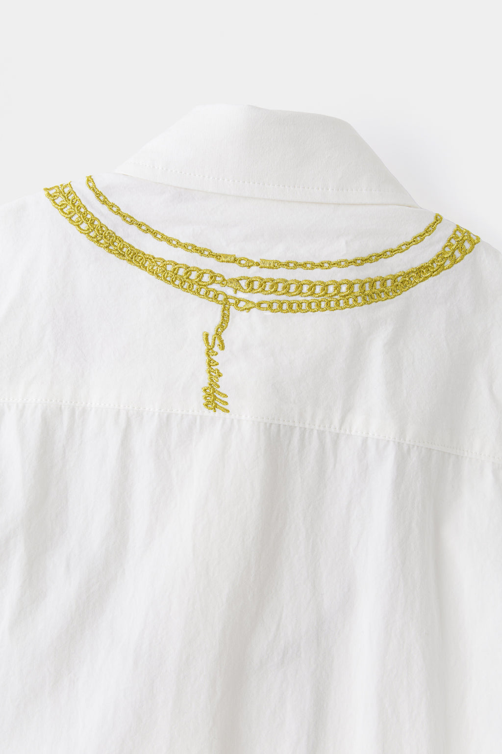 Close-up of the back yoke, where the embroidered gold chain fastens with a script Ssstufff clasp.