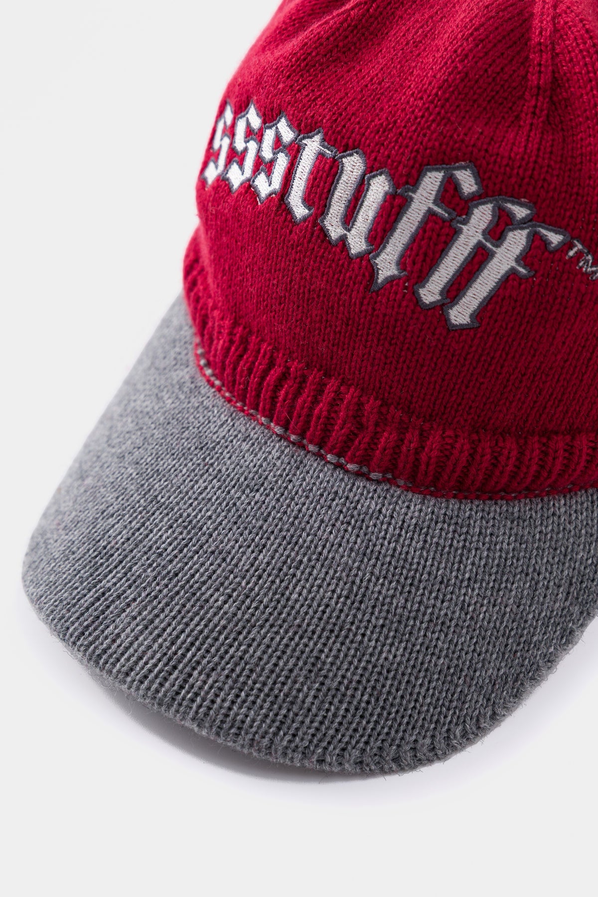 Close-up of the gothic ssstufff embroidery above the contrast grey knitted brim.
