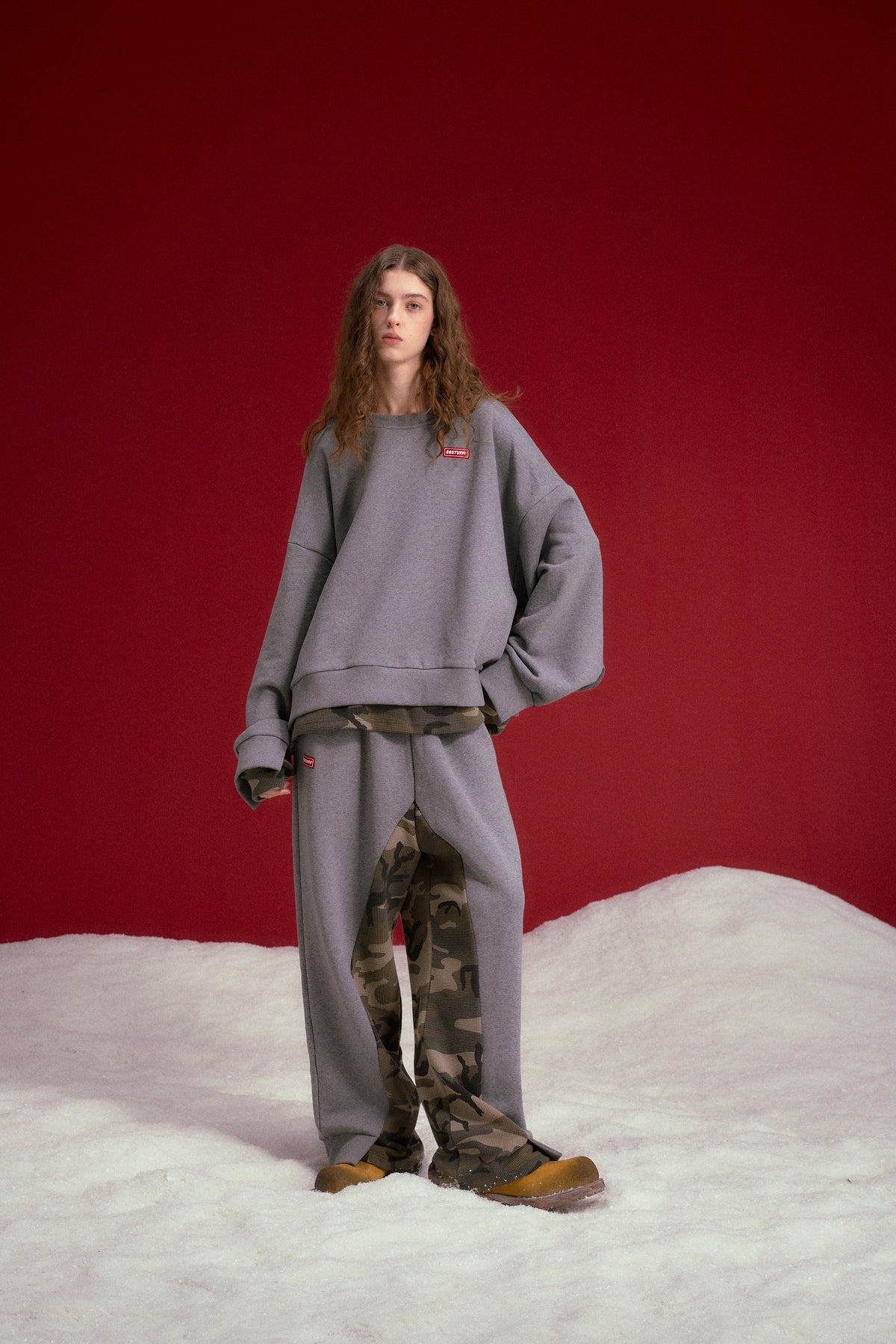 Layered Waffle Camo Crewneck in grey marl, with a waffle camo layer showing at cuffs and hem. Worn on a model, full-length front view.