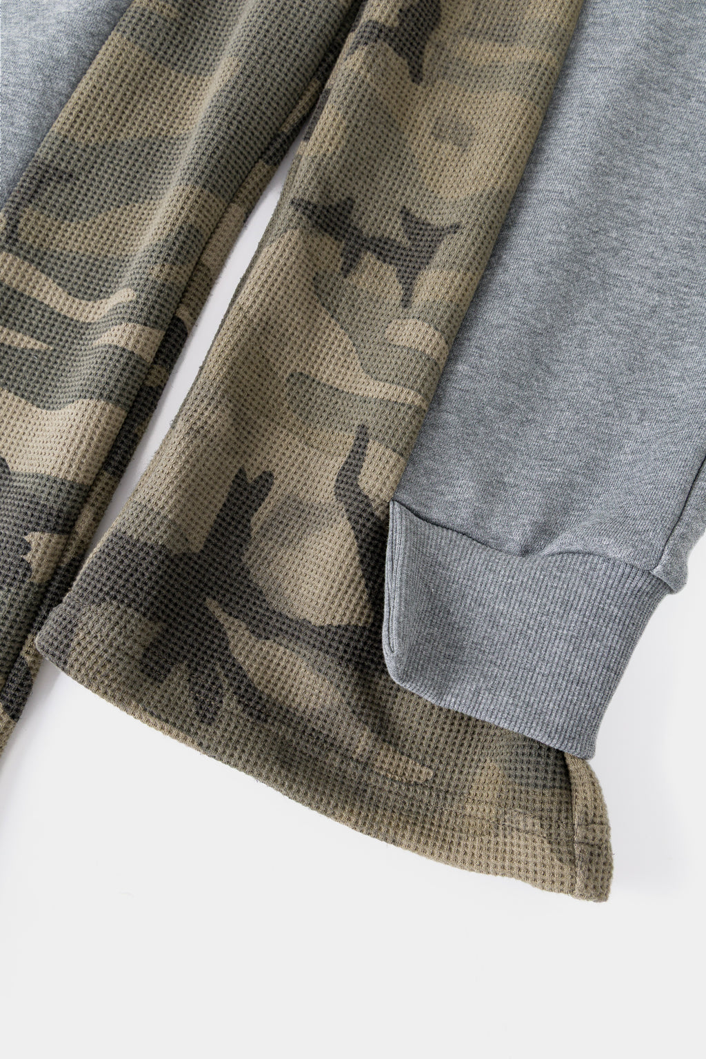 Close-up of the waffle camo underlayer emerging at the side split.