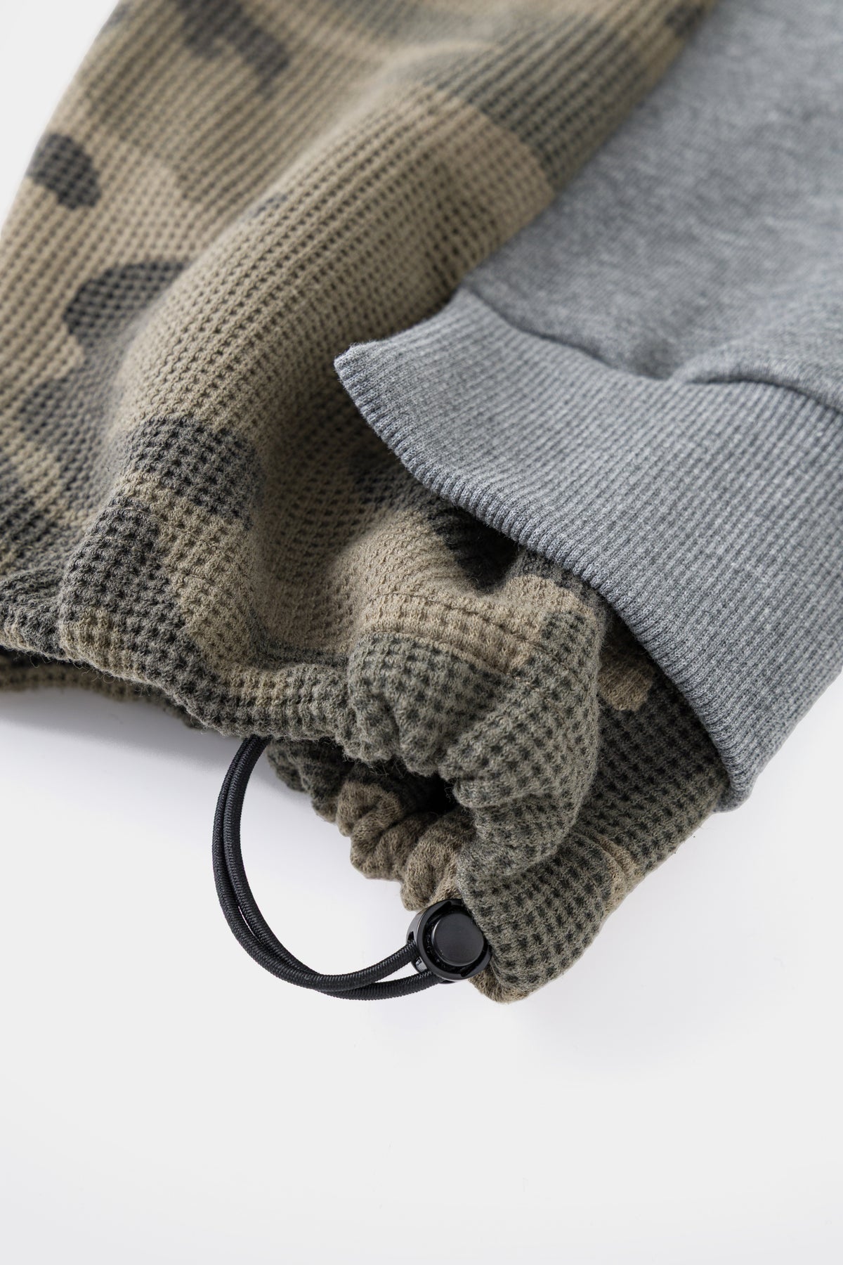 Close-up of the elasticated cuff and cord puller over the camo layer.
