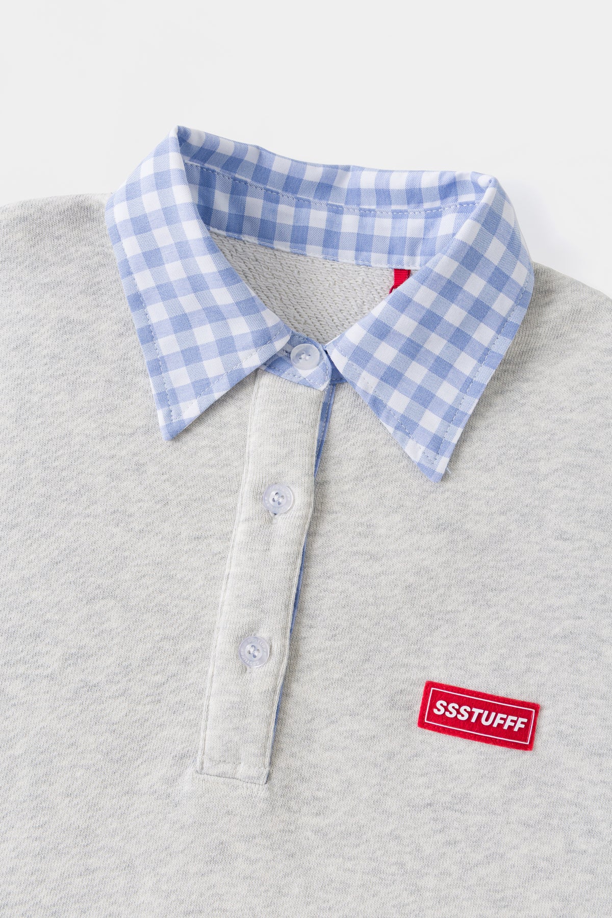 Close-up of the blue gingham collar, placket buttons and red Ssstufff tab.
