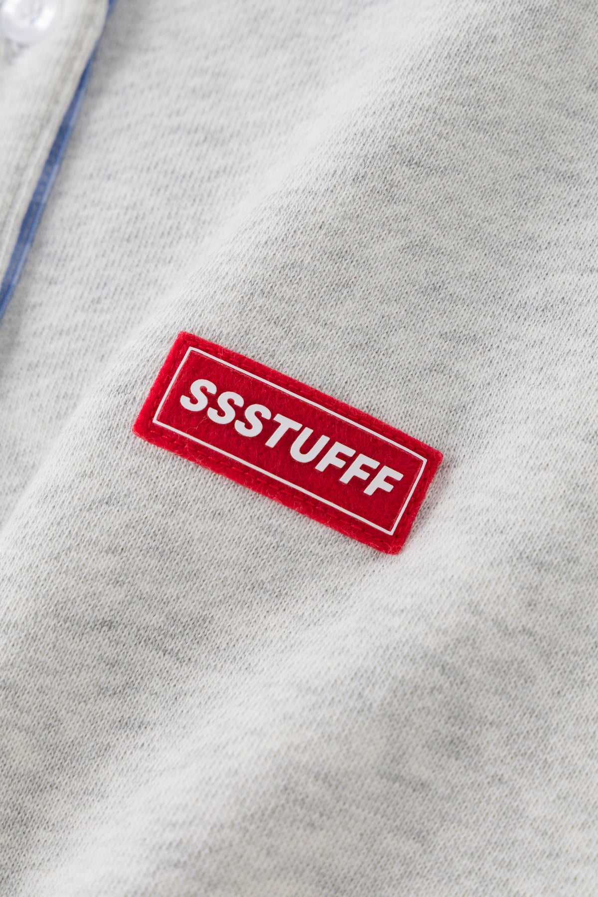 Detail of the red rubberised SSSTUFFF patch on the grey marl body.
