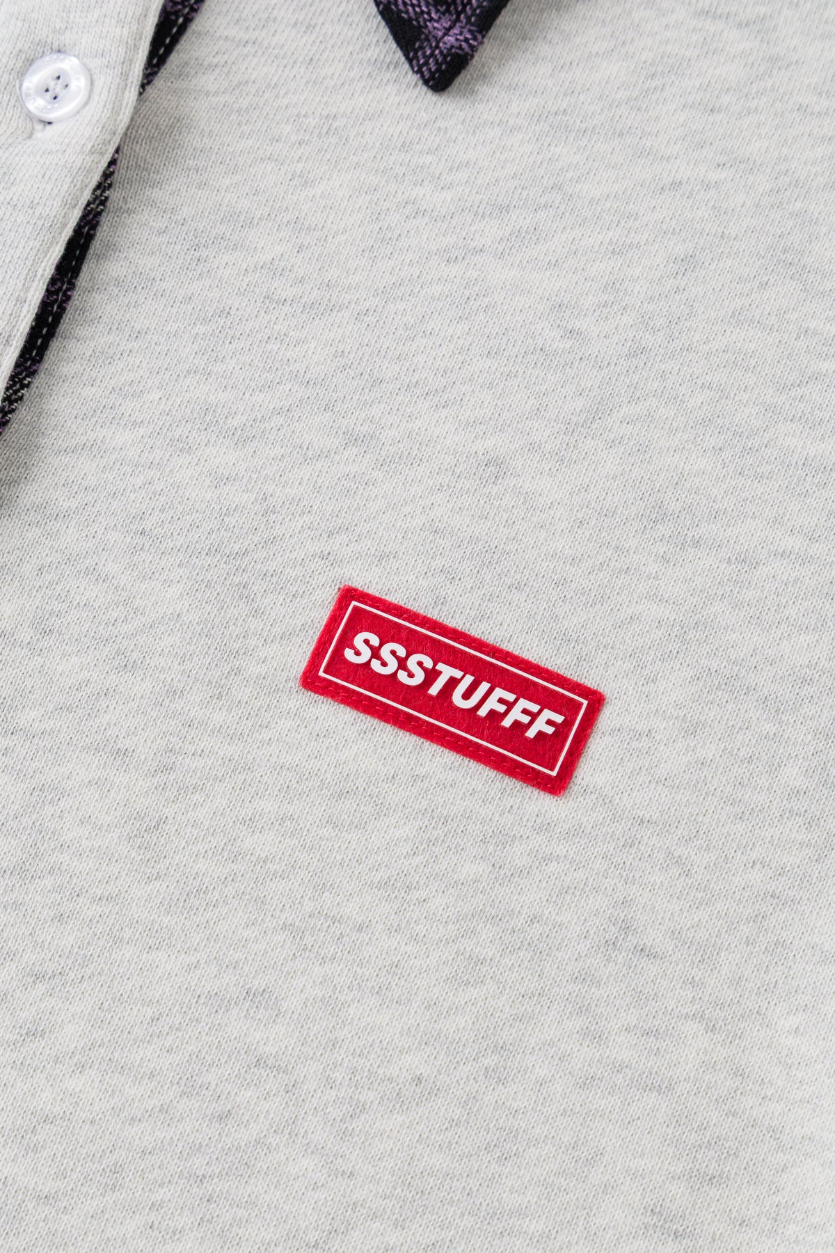 Detail of the red rubberised SSSTUFFF patch on oatmeal marl.