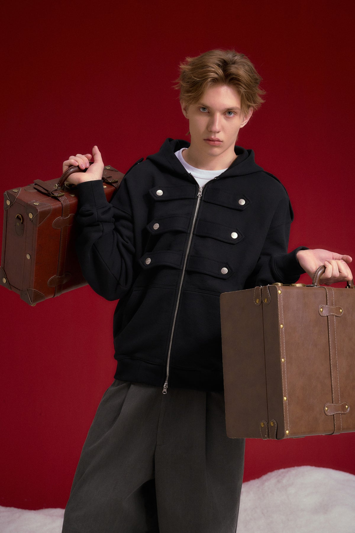 Lobby Boy Hoodie in black, with concierge chest closures and shoulder epaulettes. Worn on a model, waist-up view.