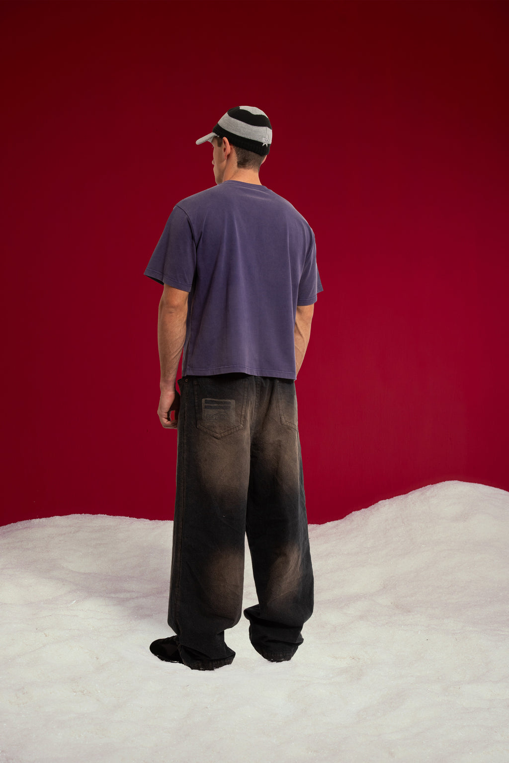 Mystery Cats Tee in washed purple, printed with the whole cast of the case redrawn as cats. Worn on a model, full-length back view.