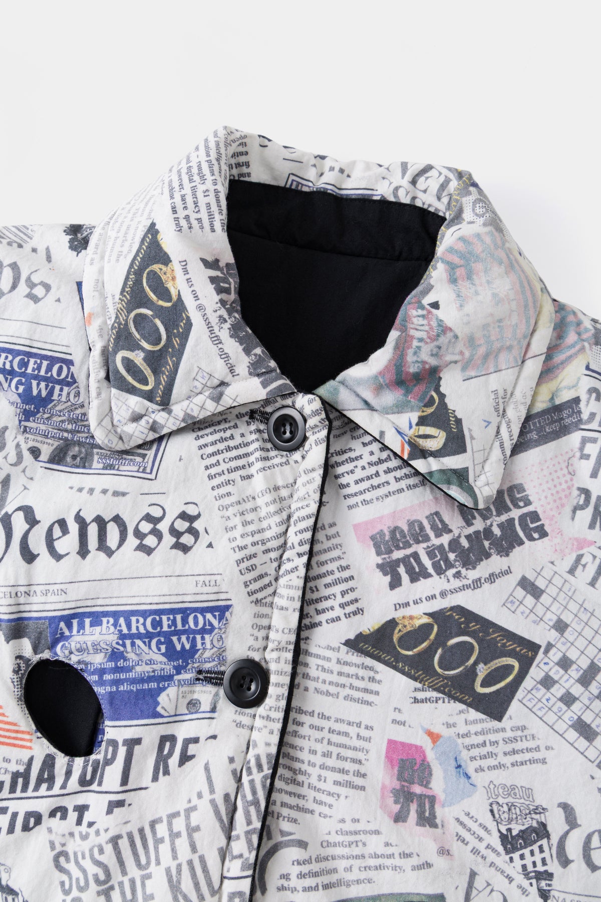 Close-up of the collar and buttoned placket on the newspaper print side, with an eye hole at the chest.