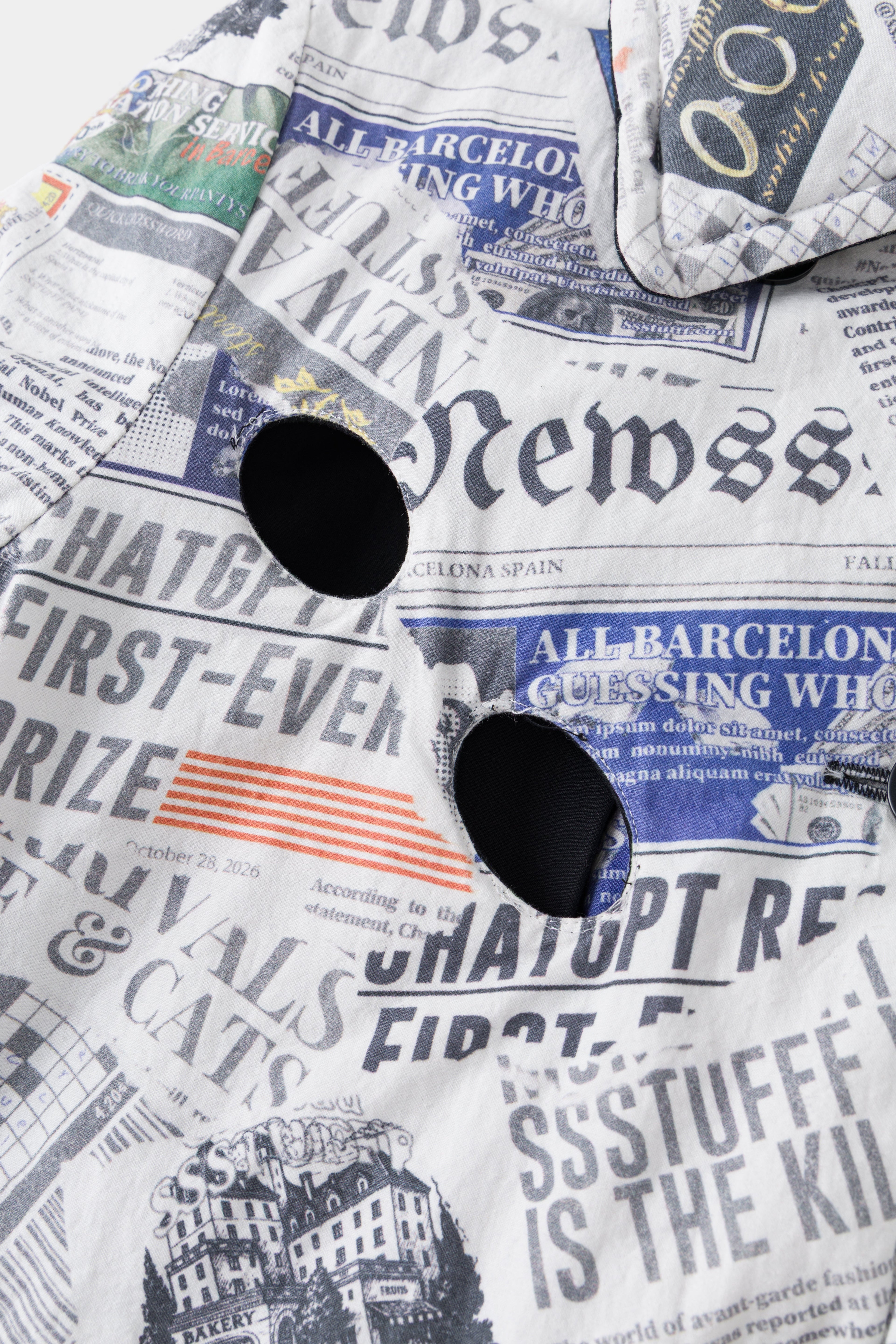 Detail of the two eye holes cut through the printed headlines at the chest.