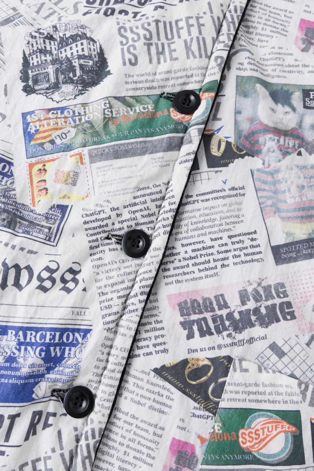 Close-up of the black buttons down the newspaper print placket.