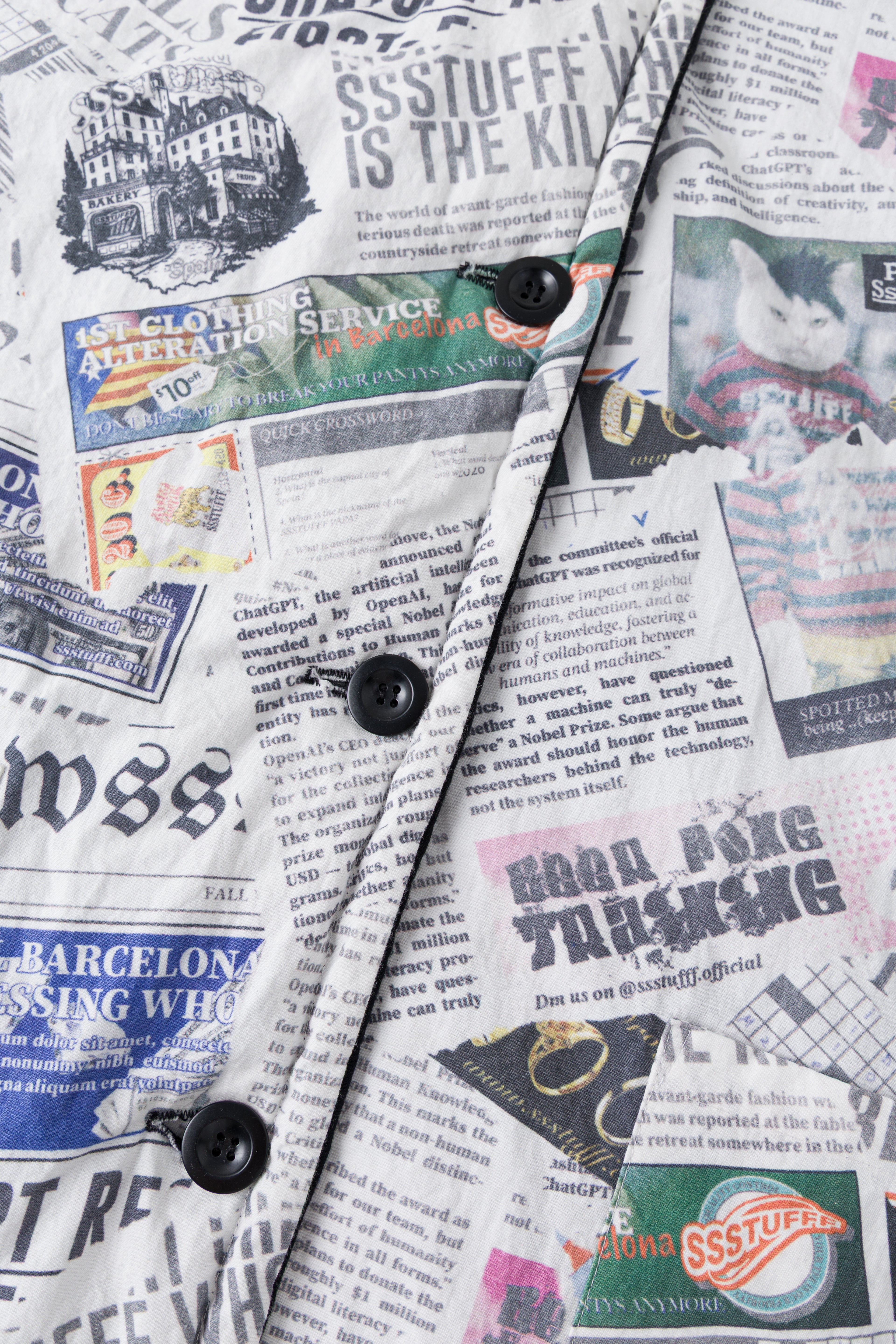 Close-up of the black buttons down the newspaper print placket.