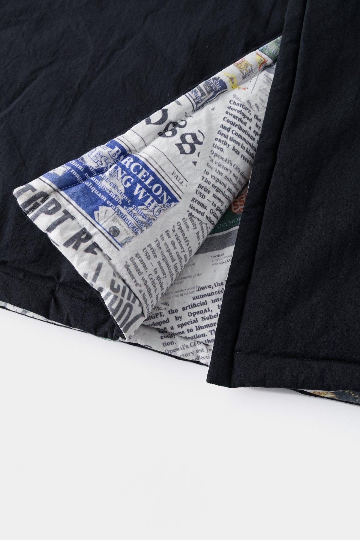 Close-up of the hem folded back, showing the newsprint side against the black side.