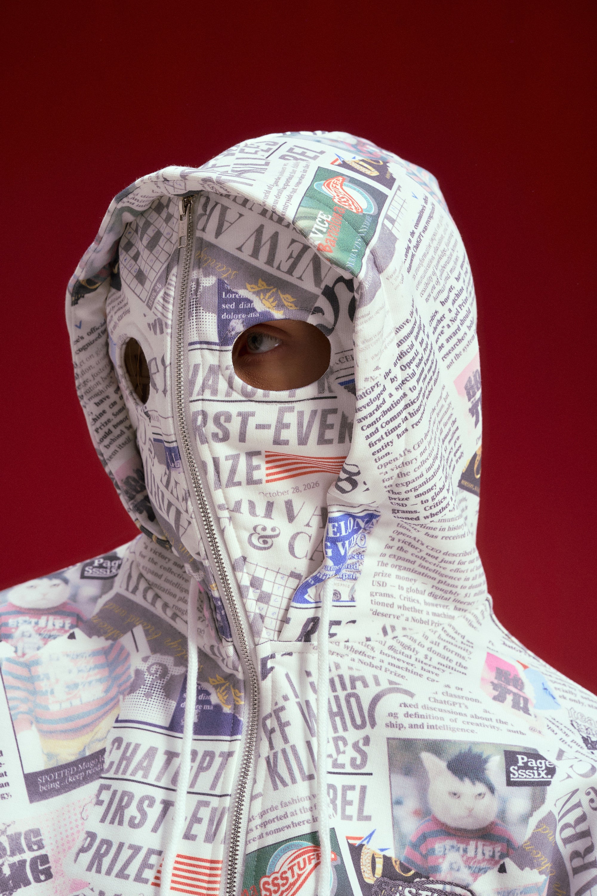 Newspaper Spy Hoodie, a zip-up hoodie printed all over with newsprint. Worn on a model, waist-up view.