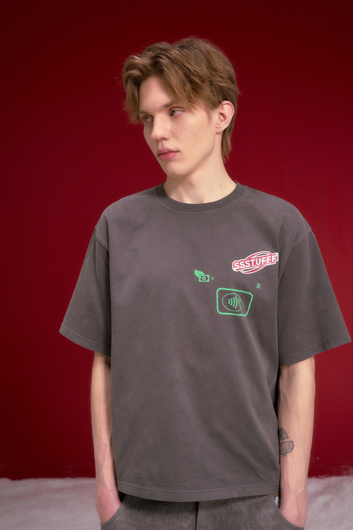 NFC ATM Tee in washed charcoal, with a contactless payment graphic at the chest. Worn on a model, waist-up view.
