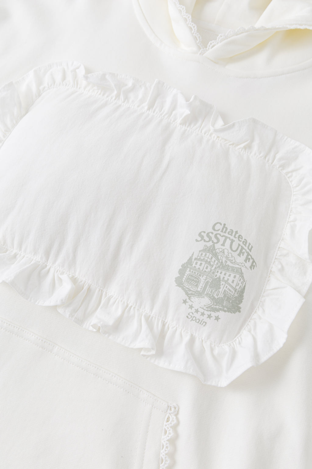 Detail of the ruffled pillow patch and the Château SSSTUFFF crest printed on it.