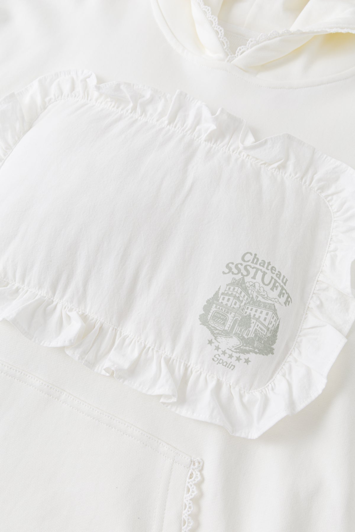 Detail of the ruffled pillow patch and the Château SSSTUFFF crest printed on it.