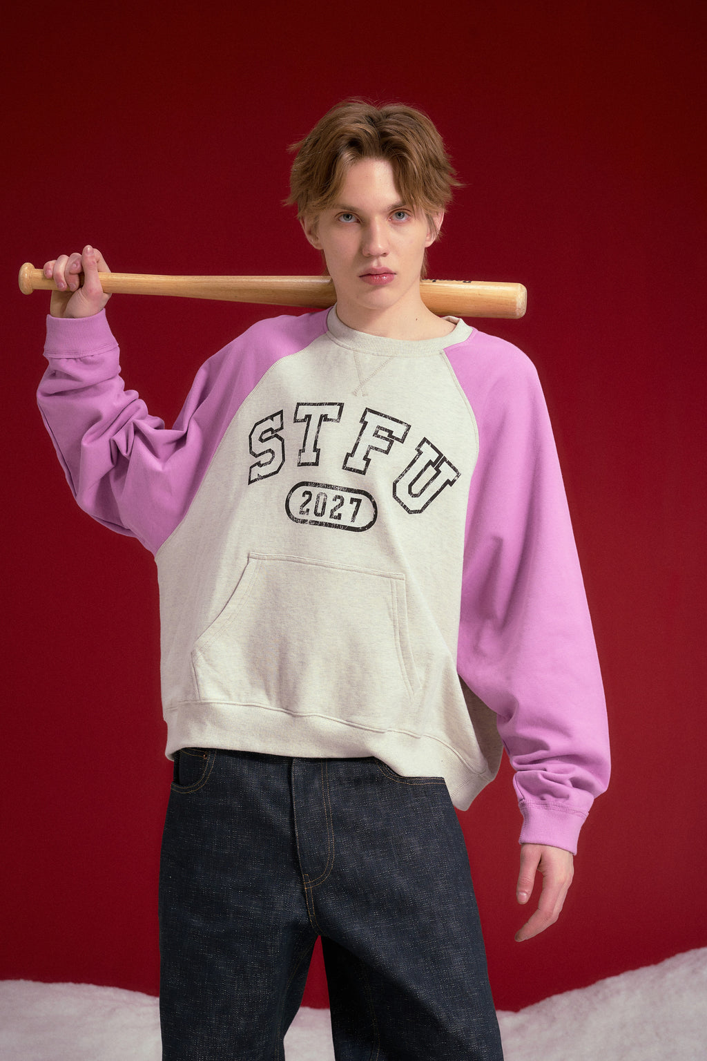 Raglan Pocket Crewneck in oatmeal marl with orchid sleeves, printed STFU 2027 at the chest. Worn on a model, waist-up view.