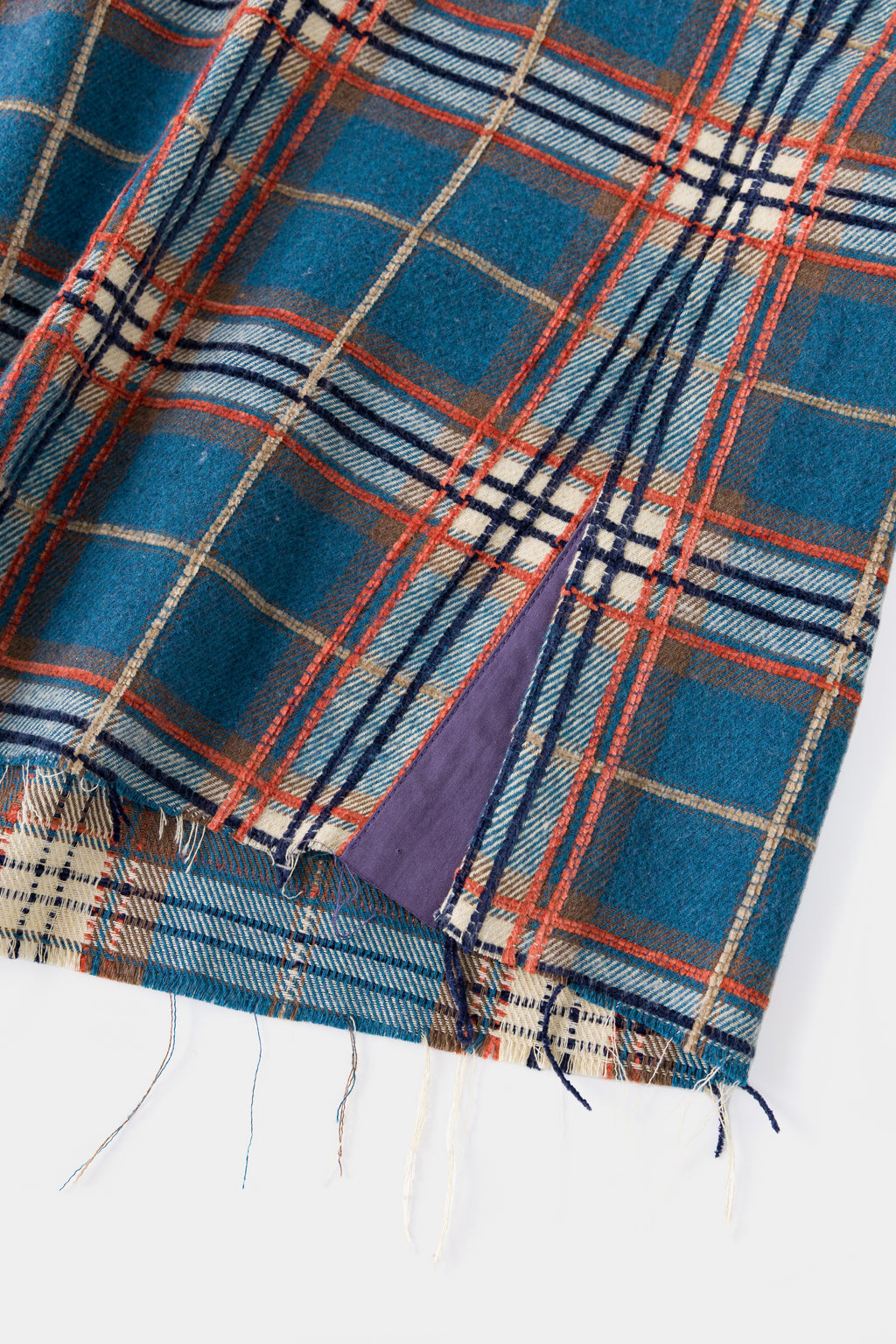 Close-up of the raw, unfinished hem with loose threads.