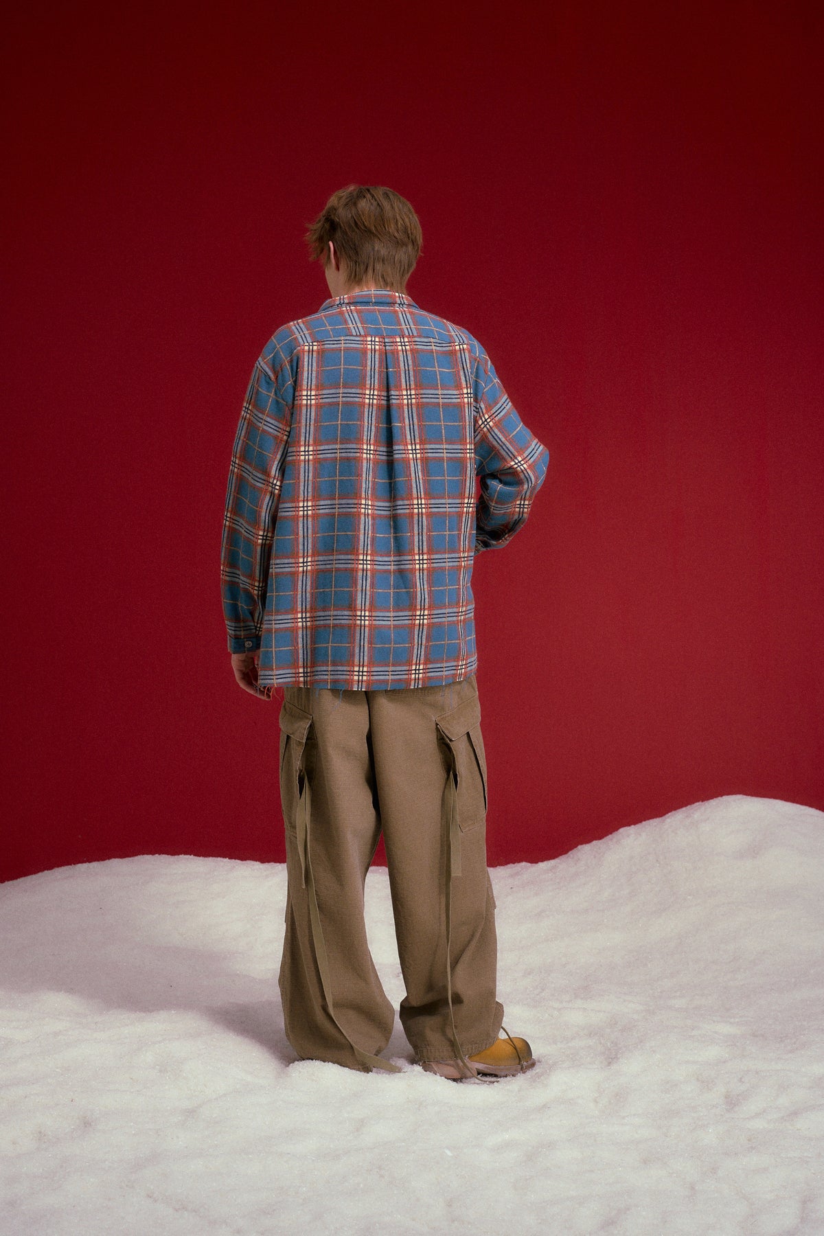 Raw Edge Plaid Shirt in blue and orange check, with every seam left unfinished. Worn on a model, full-length back view.