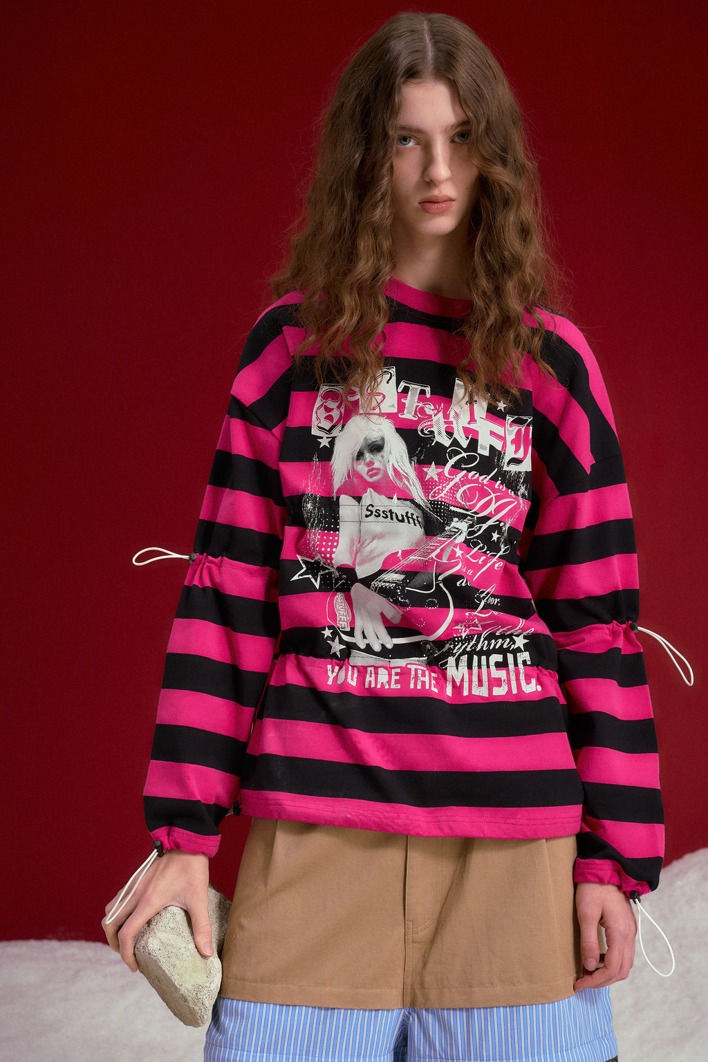 Adjustable Rock Striped L/S Tee in pink and black stripes, printed with a rock poster graphic at the chest. Worn on a model, waist-up view.