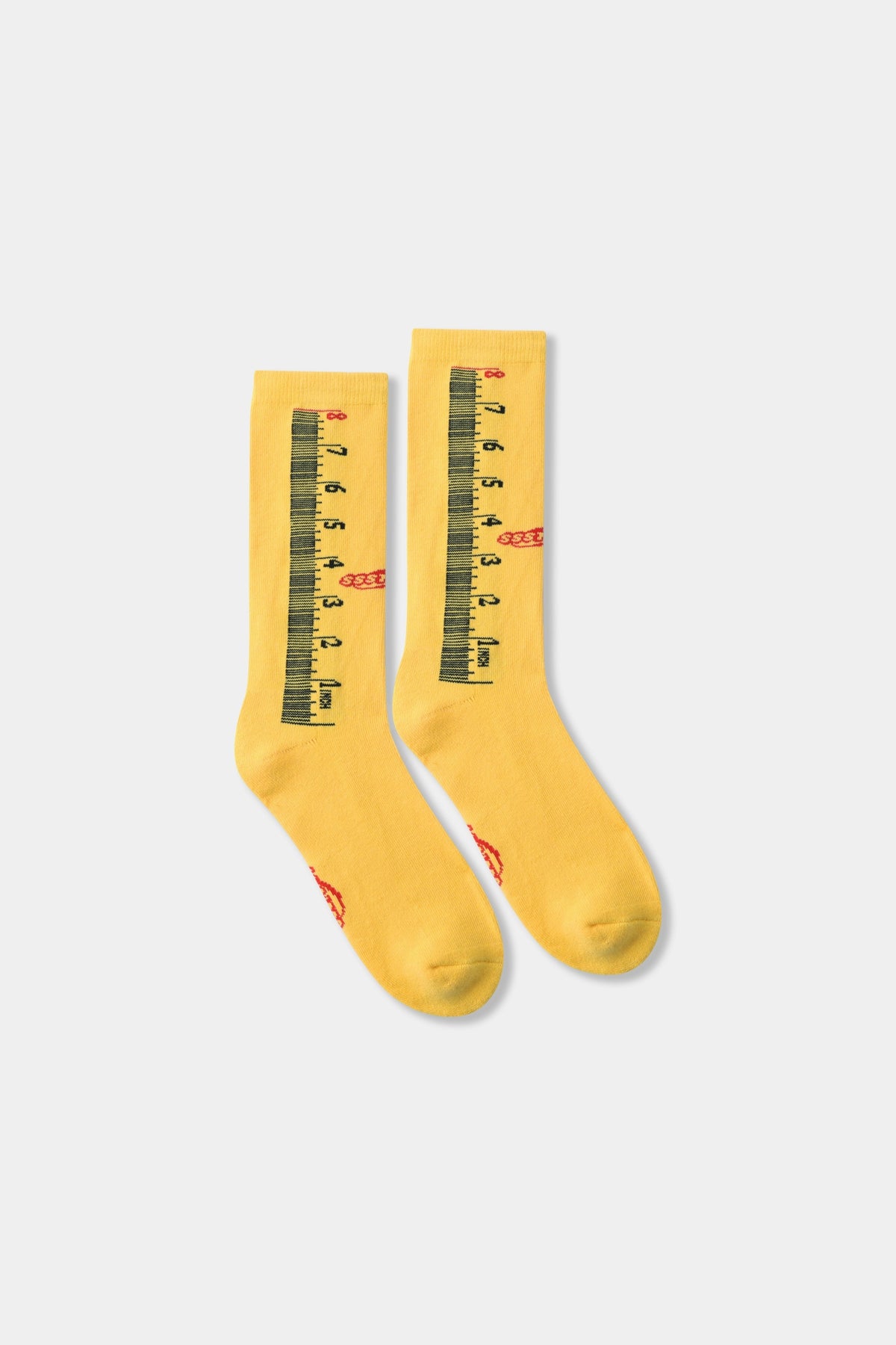 Ruler Socks in yellow, ribbed crew socks knitted end to end as a tape measure with a red Ssstufff logo at the ankle.