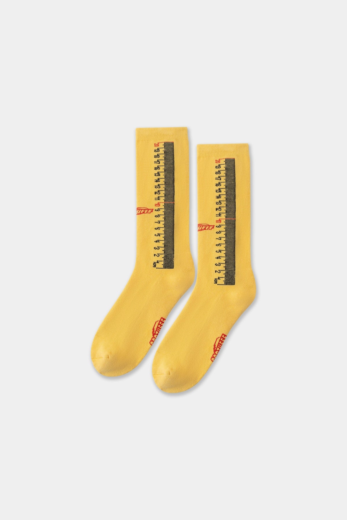 Ruler Socks in yellow, the pair side by side showing the knitted tape-measure markings.