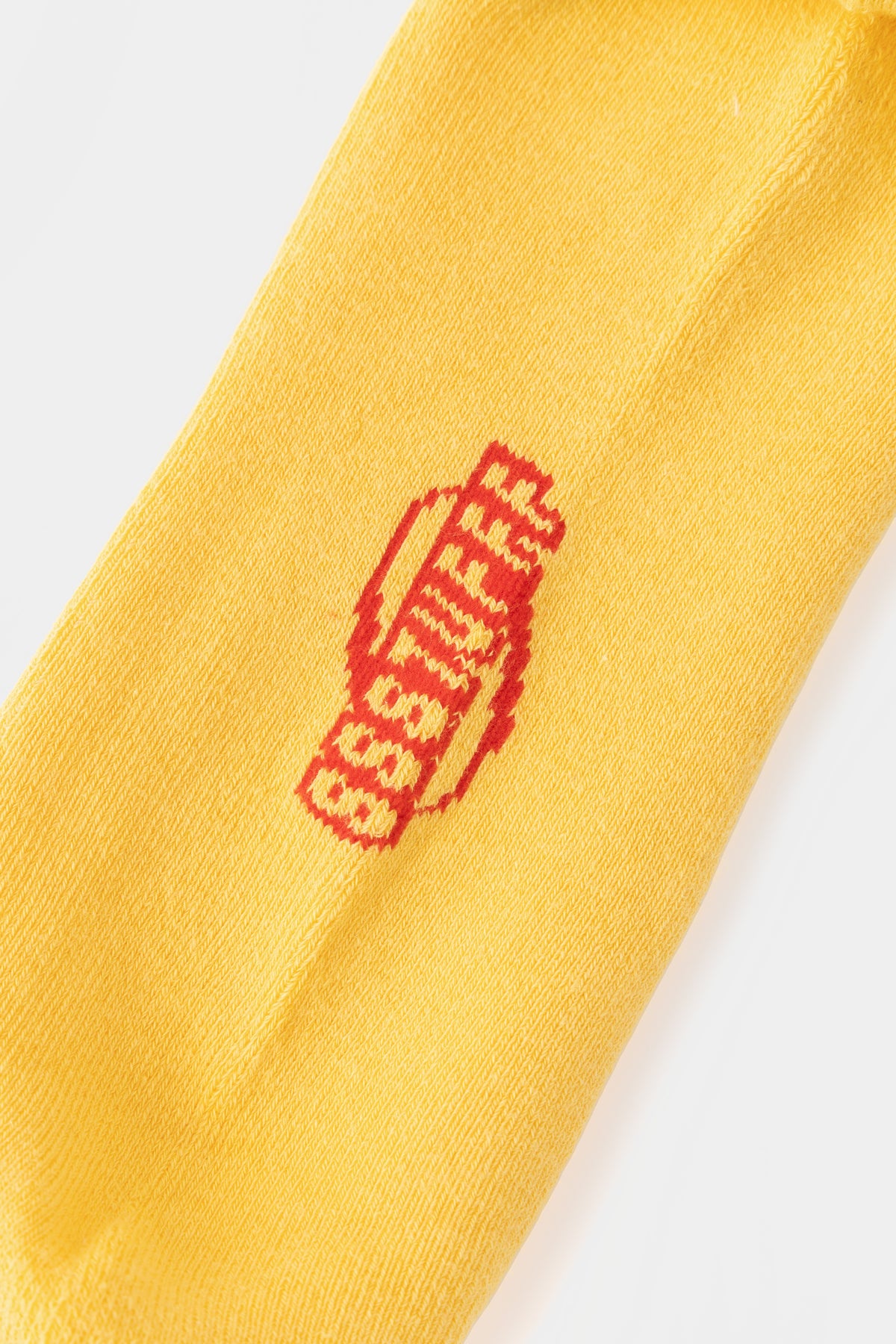 Detail of the red SSSTUFFF logo knitted into the yellow rib.