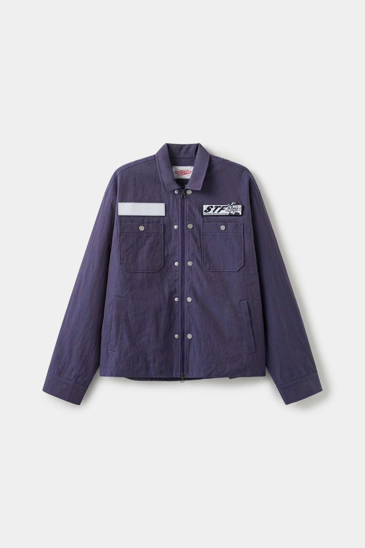 Secret Plumber Jacket in dark violet cotton twill, front view with the blank name patch and the STF Plumbing Services patch at the chest.