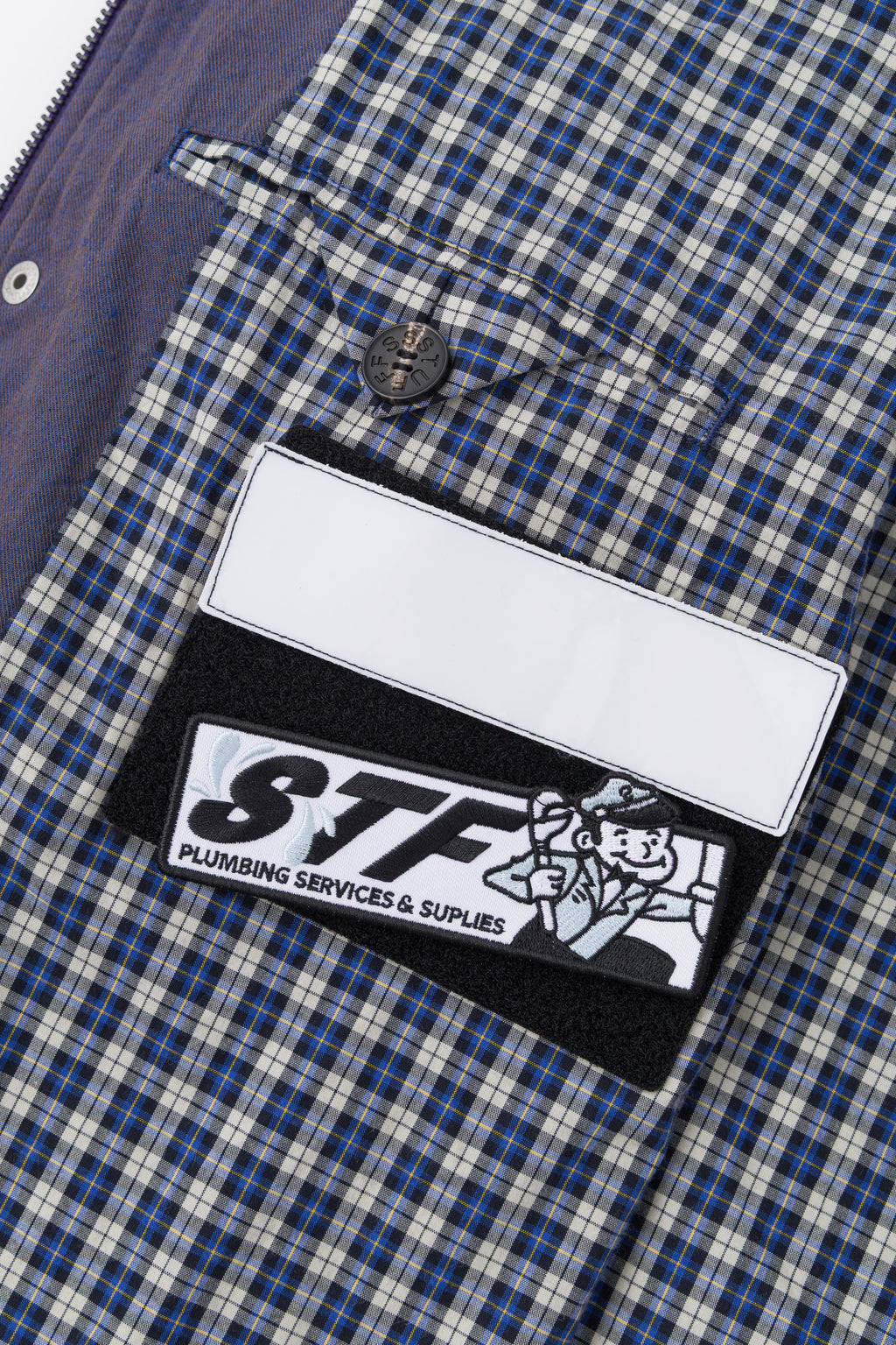 Detail of the blue check lining with the blank name patch and the STF patch.