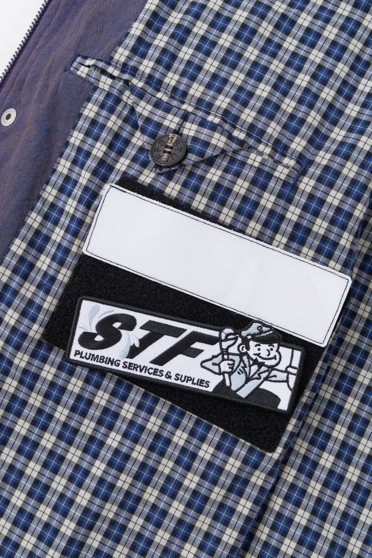 Detail of the blue check lining with the blank name patch and the STF patch.