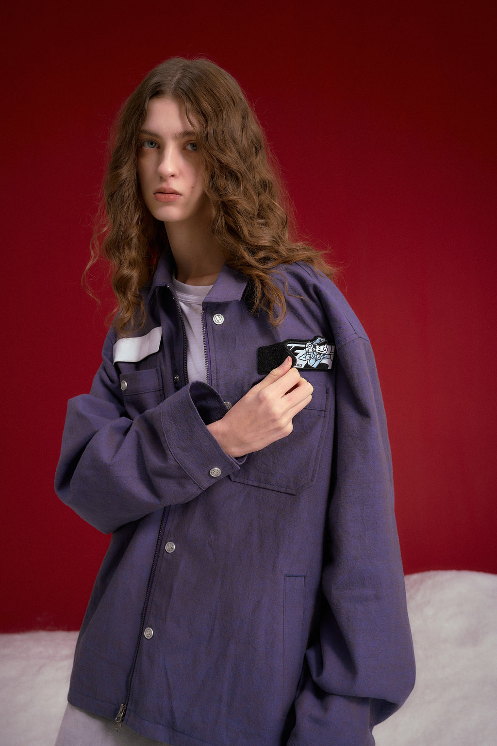 Secret Plumber Jacket in lilac, with velcro chest pockets and a Plumbing Services print at the back. Worn on a model, waist-up view, close-up of the velcro chest pocket.