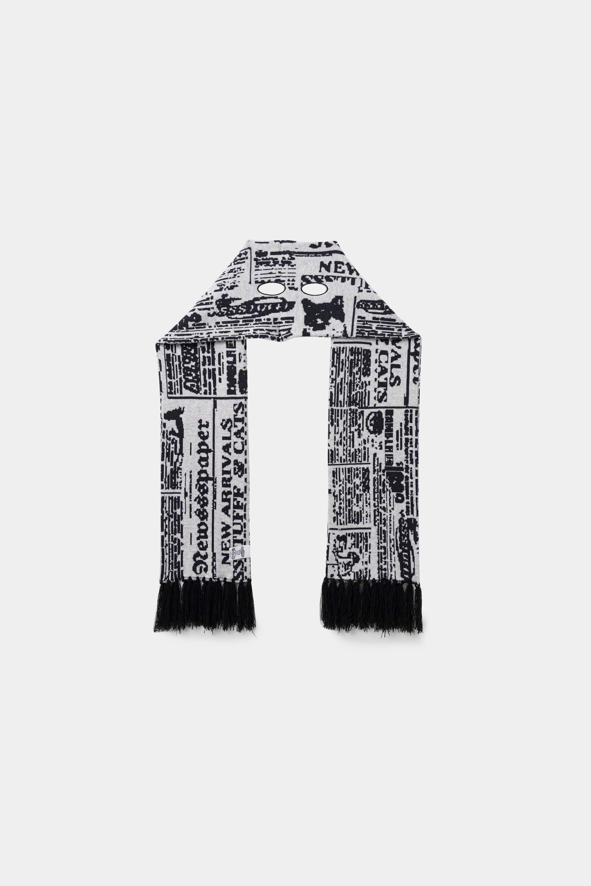 Back view of the newsprint scarf, folded double to show the full length and the fringed ends.