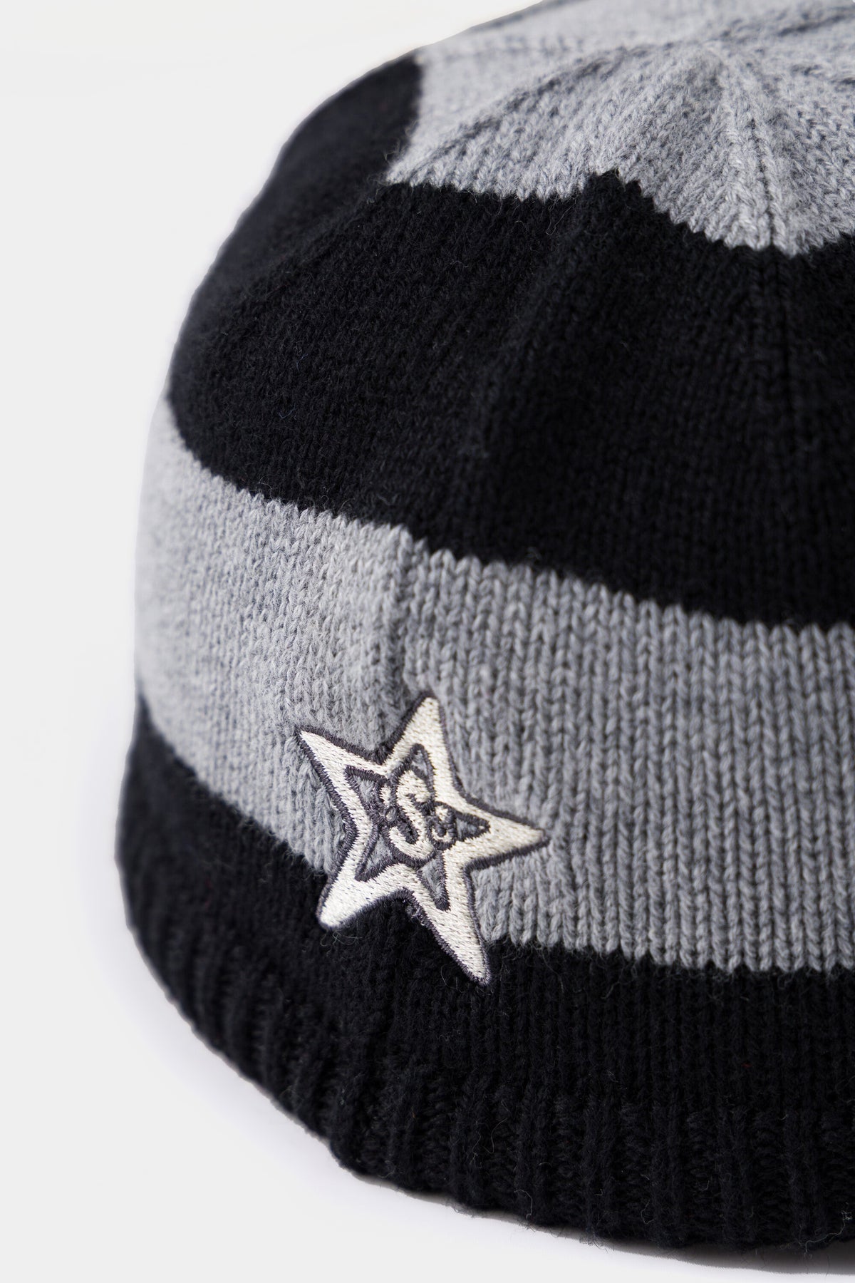 Detail of the embroidered star patch on the side of the Striped Knitted Cap.