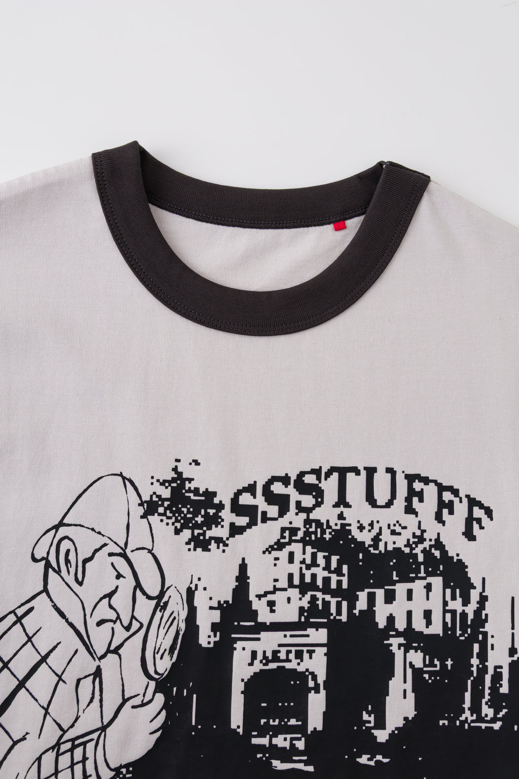 Detail of the black ringer collar and red pin on the Thermo Reveal Footsteps Tee.